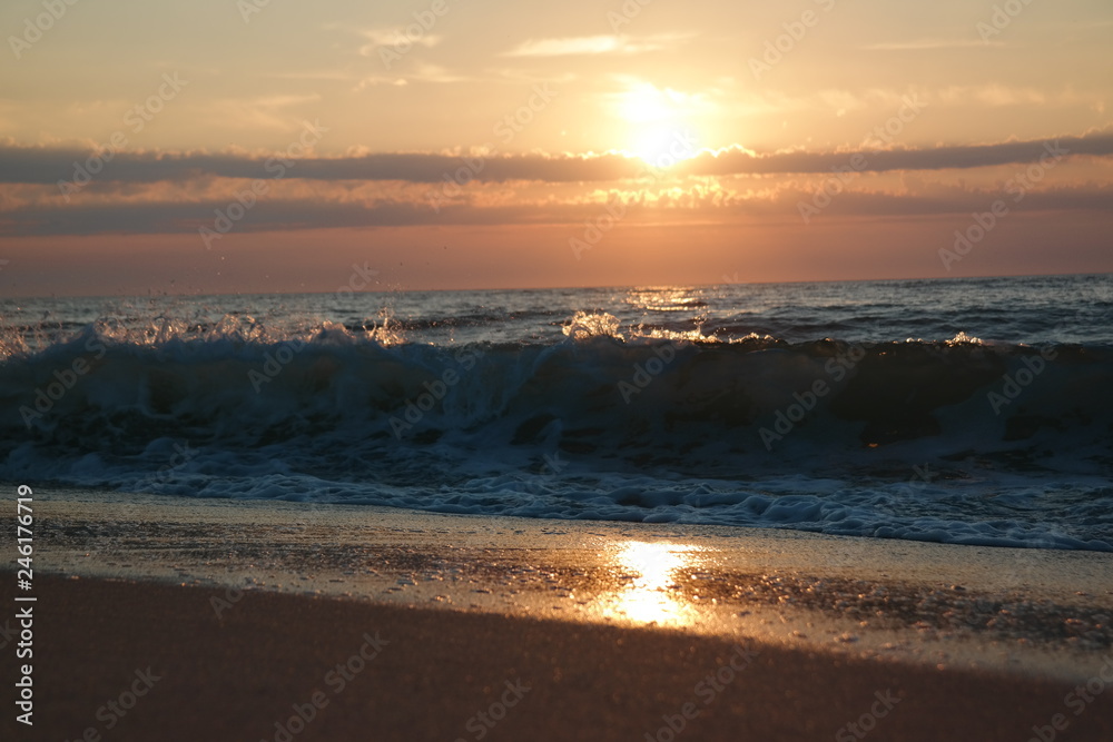 Spiegelung vor einer Welle bei Sonnenuntergang
