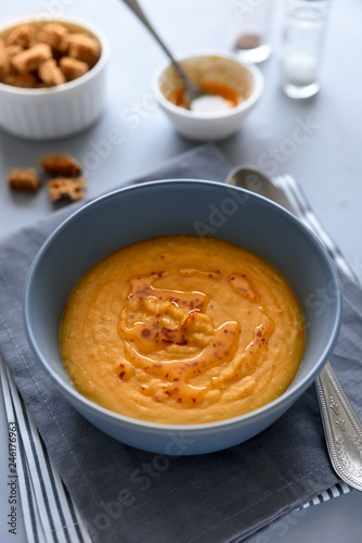 Bowl of red lentil soup on gray wooden background. Vegetarian food concept