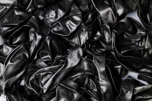 Pile of deflated black balloons on a white background. Clean pure baloon template. Logo, texture, pattern presentation plain aerostat design element. photo