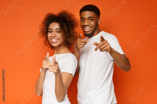 Fotografía Joyful young couple pointing fingers at camera