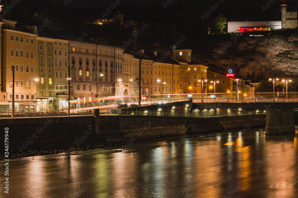 Stadt am Fluss bei Nacht mit Beleuchtung und Lichtstreifen