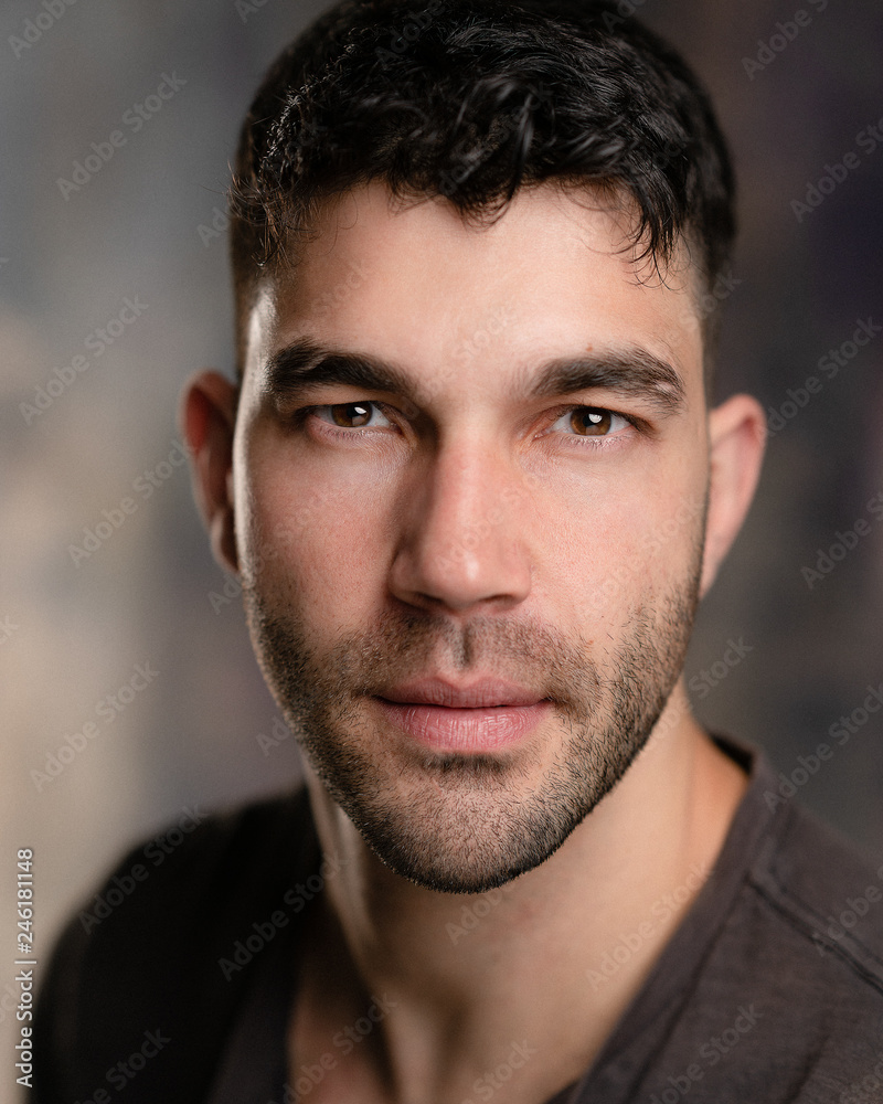 Obraz premium Handsome caucasian white male with black short hair and stubble with brown t shirt