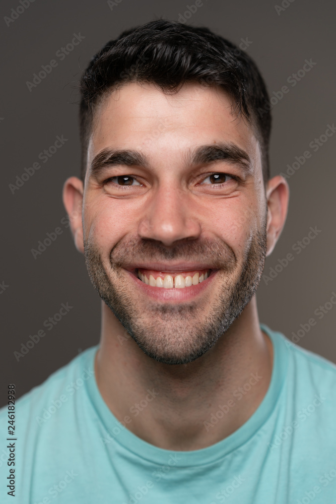 Handsome caucasian white male with black short hair and stubble with light blue t shirt Handsome caucasian white male with black short hair and stubble with light blue t shirt