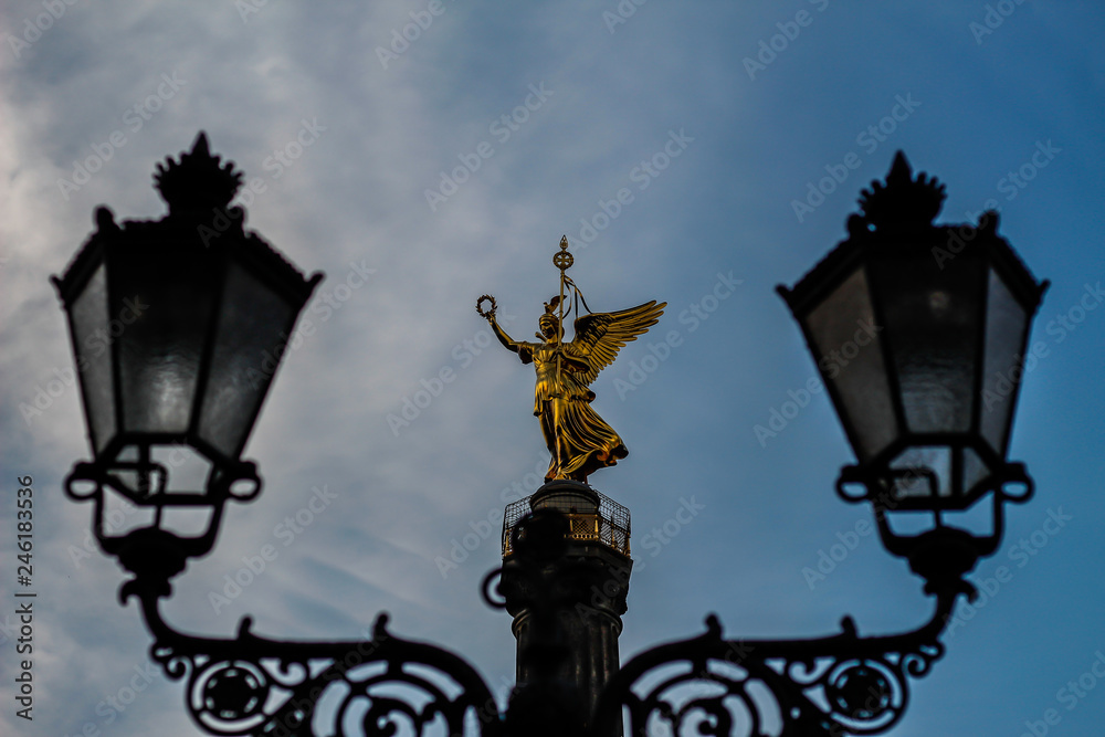 Die Statue Viktoria auf der Siegessäule zwischen zwei Laternen