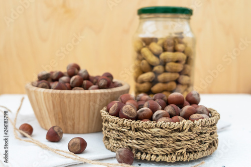 he concept of tree nuts and peanuts. In a glass jar, wicker basket and wooden bowl.