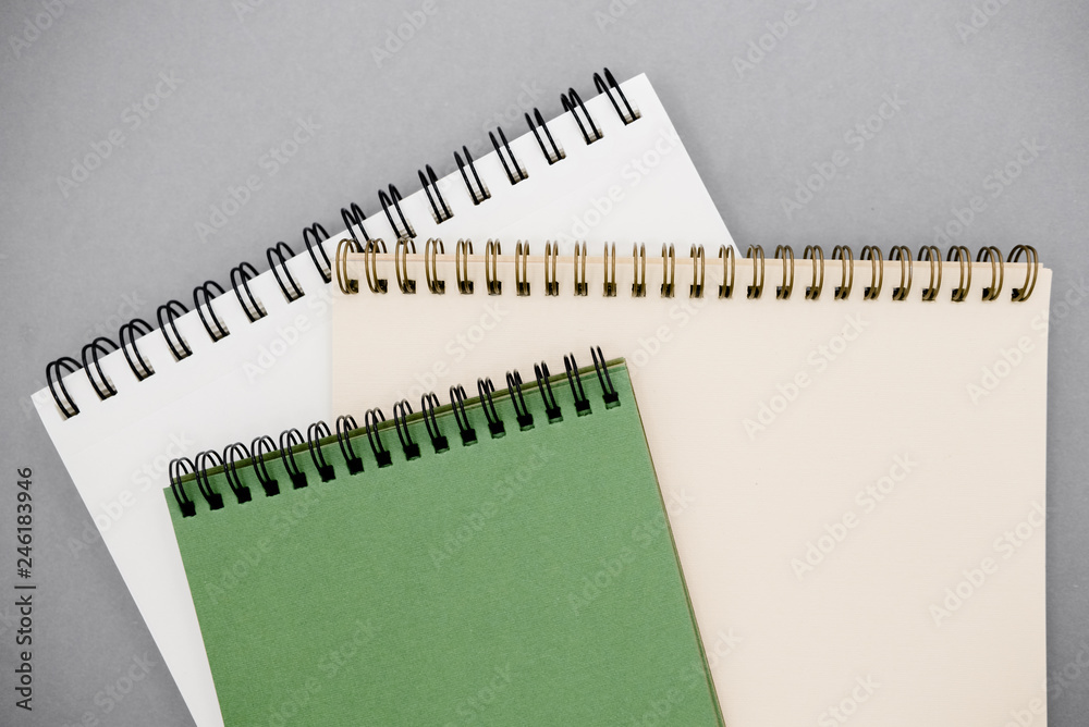 Flat Lay top view Photo of notepads on beige background with copy space.Creative flat lay photo of workspace desk with white and green notebooks Flat Lay top view Photo of notepads on beige background with copy space.Creative flat lay photo of workspace desk with white and green notebooks