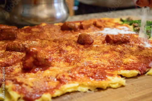 Cooking polenta  typical  traditional  Italian food made with cornmeal and water. Polenta topped with vegetables  sausage and pork with gravy  on wooden pastry. Lunch at home with the family.