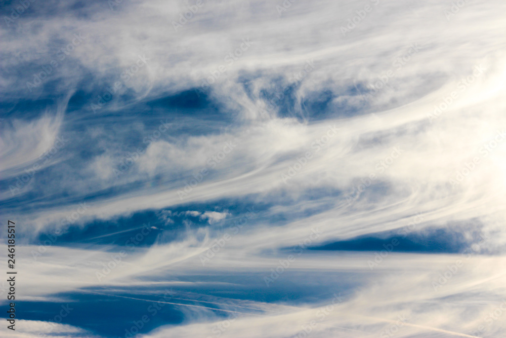blue sky background with contrails and clouds 