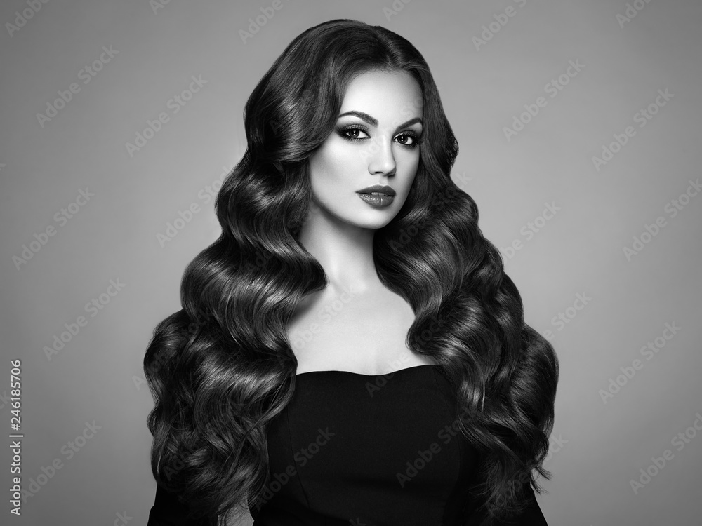 Beautiful woman in elegant black evening dress. Brunette Girl with Long Healthy and Shiny Curly Hair. Care and Beauty. Beautiful Model Woman with Wavy Hairstyle Stock Photo | Adobe Stock Beautiful woman in elegant black evening dress. Brunette Girl with Long Healthy and Shiny Curly Hair. Care and Beauty. Beautiful Model Woman with Wavy Hairstyle Stock Photo | Adobe Stock