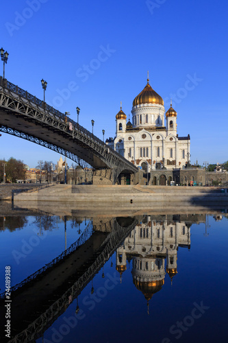 Cathedral of Christ the Saviour and Patriarshiy Bridge with reflection on water surface of Moskva river at sunny spring morning