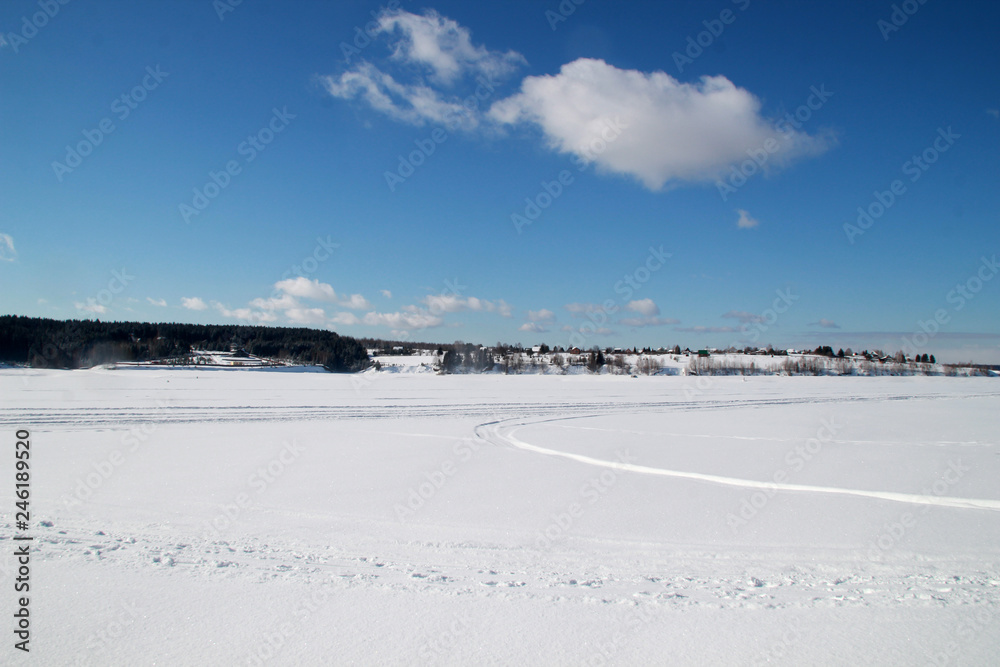 winter landscape with frozen lake and blue sky