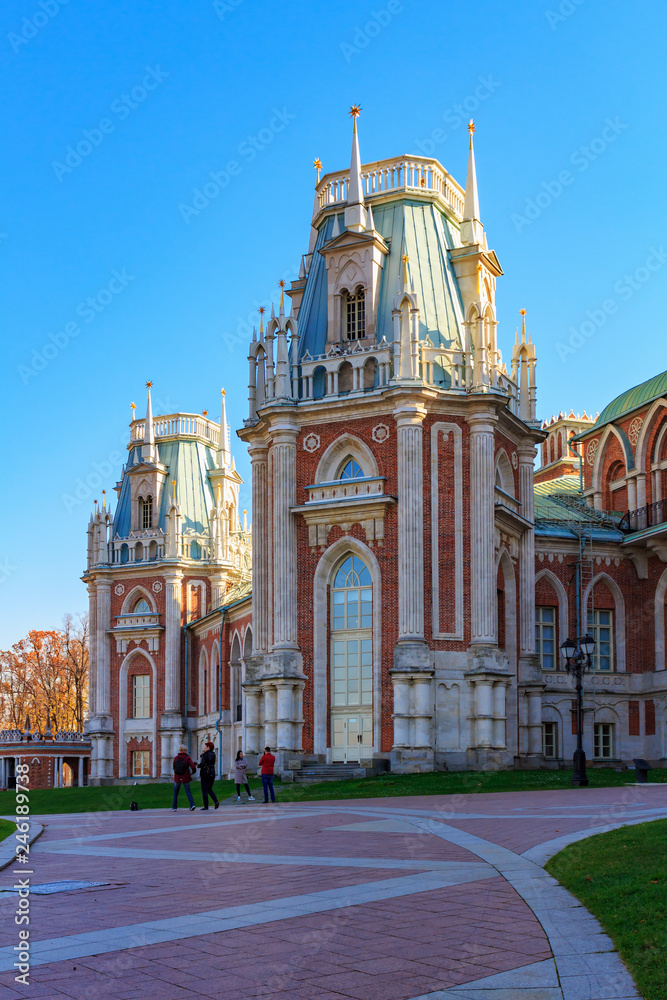 Tourists on alley near Grand palace in Tsaritsyno park in Moscow at sunny autumn day