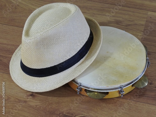 A pandeiro (tambourine), a Brazilian percussion musical instrument, and a samba player (sambista) hat. The instrument is widely used to accompany samba and choro, two popular Brazilian rhythms.