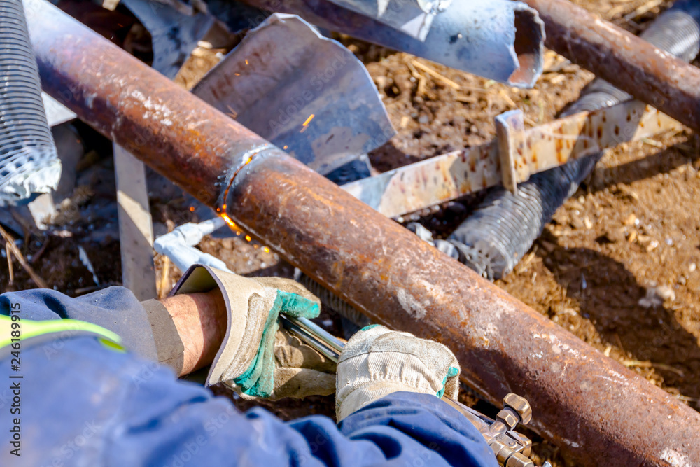 Worker is cutting scrap metal with acetylene torch Stock Photo | Adobe