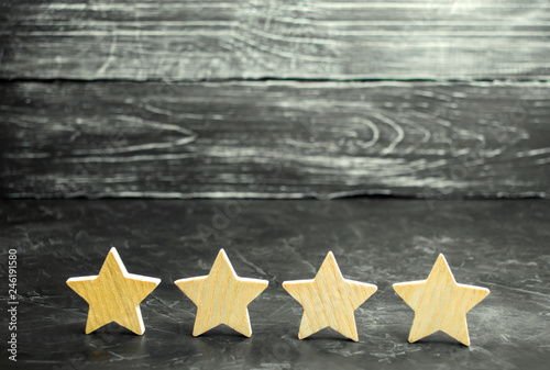 Four wooden stars. The concept of rating and evaluation. The rating of the hotel, restaurant, mobile application. Quality service, buyer choice. Success in business. selective focus