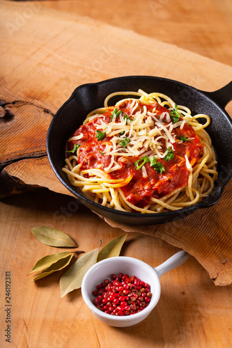 Food concept Homemade spaghetti bolognese in iron cast on wooden background with copy space