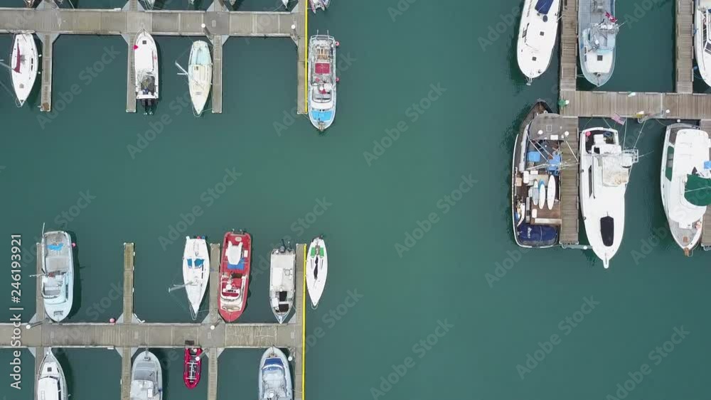 Aerial birds eye view flying over commercial and sports boats docked in the harbor in Homer, Alaska