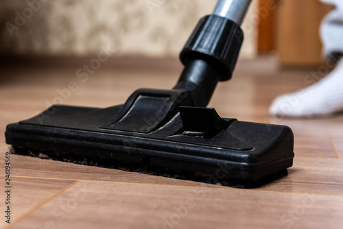 Vacuuming laminate floor.