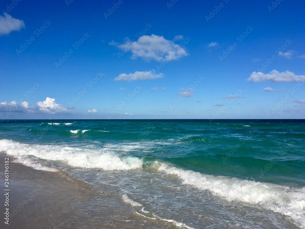 Atlantic Ocean off South Beach in Miami, Florida with blue water, some puffy clouds and white surf