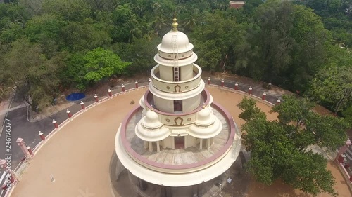 Aerial: Traditional Hindu Sarada temple, South India, temple in jungle on a hill Shiva Giri among tropical palm trees Ashram Varkala Kerala. Sculpture on front of a Hindu Temple in Kerala.