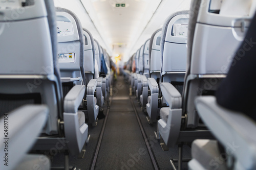 airline passenger seats and aisle in airplane cabin