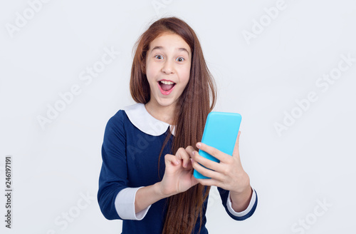 Portrait of a cheerful girl who holds a smart phone in her hands in front of her.