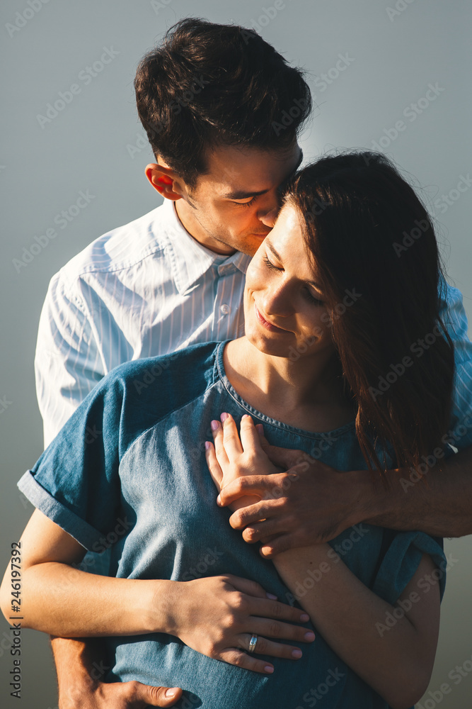 Fototapeta premium Young Caucasian Man Hugging Pregnant Wife
