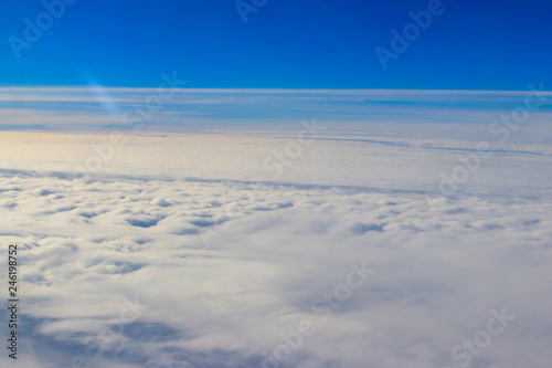 Beautiful white clouds in blue sky. View from airplane