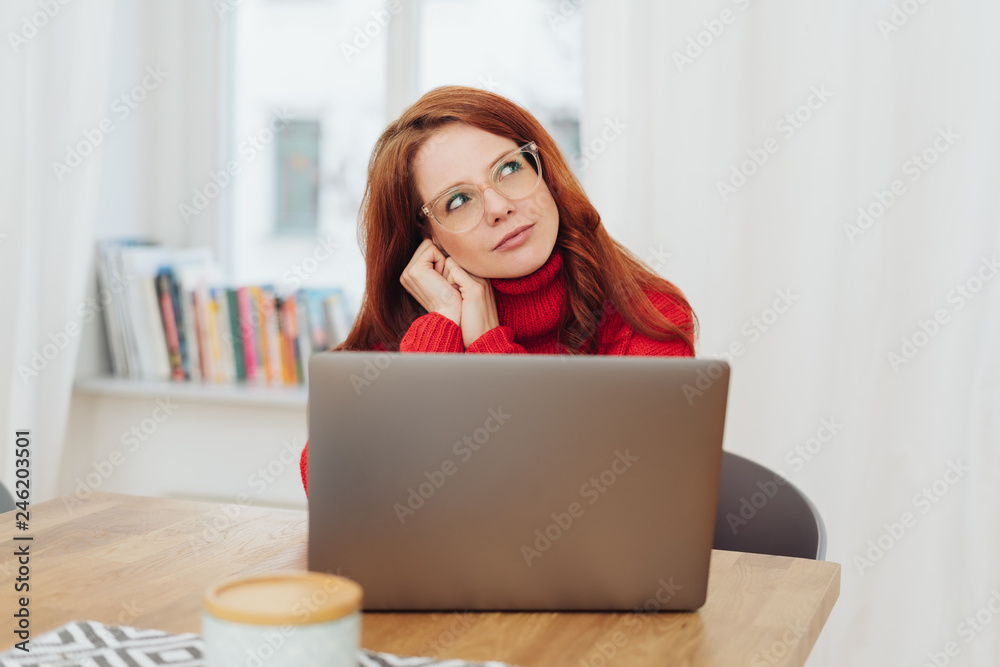 Attractive redhead woman sitting deep in thought Attractive redhead woman sitting deep in thought