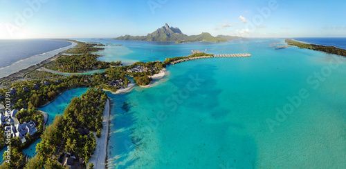 Aerial panoramic landscape view of the island of Bora Bora in French Polynesia with the Mont Otemanu mountain surrounded by a turquoise lagoon, motu atolls, re photo