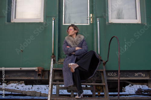 young woman in train station at sunny winter day