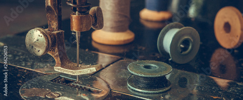 Old sewing machine retro, details of a coarse plan, coils of thread, in a vintage style, the concept of a tailor's clothing history selective focus