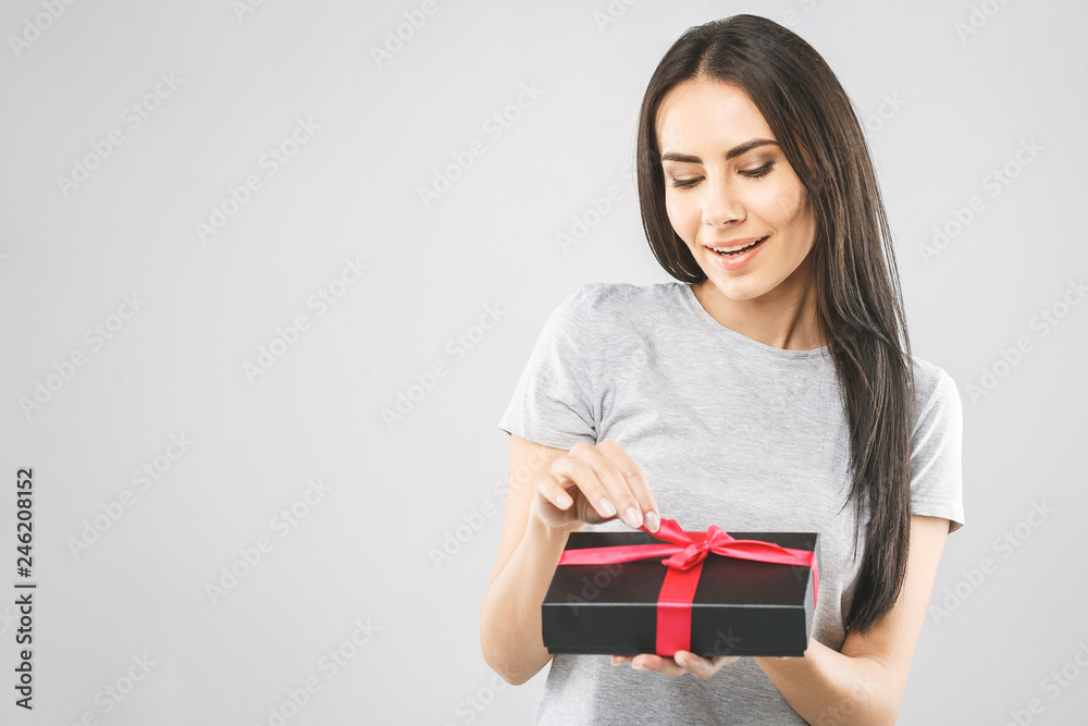 Smiling beautiful young woman hold black gift box. Smiling beautiful young woman holding black gift box. Isolated over white background. Smiling beautiful young woman hold black gift box. Smiling beautiful young woman holding black gift box. Isolated over white background.