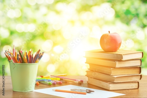 Stack of colorful books and fresh apple