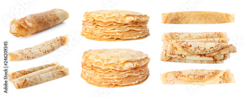 Set of rolled and stacked tasty thin pancakes on white background