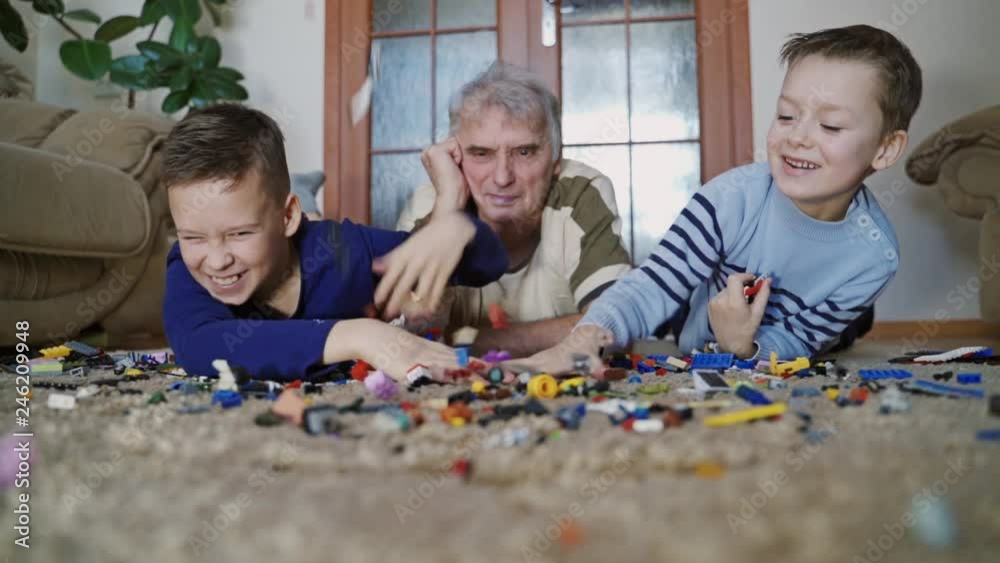Little boys are playing with colored blocks on a floor. Educational toys. Slow motion Little boys are playing with colored blocks on a floor. Educational toys. Slow motion