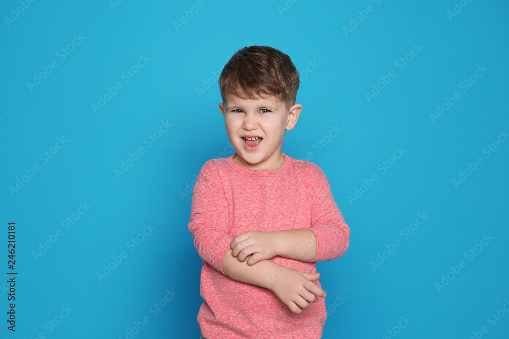 Little boy scratching arm on color background. Annoying itch Little boy scratching arm on color background. Annoying itch