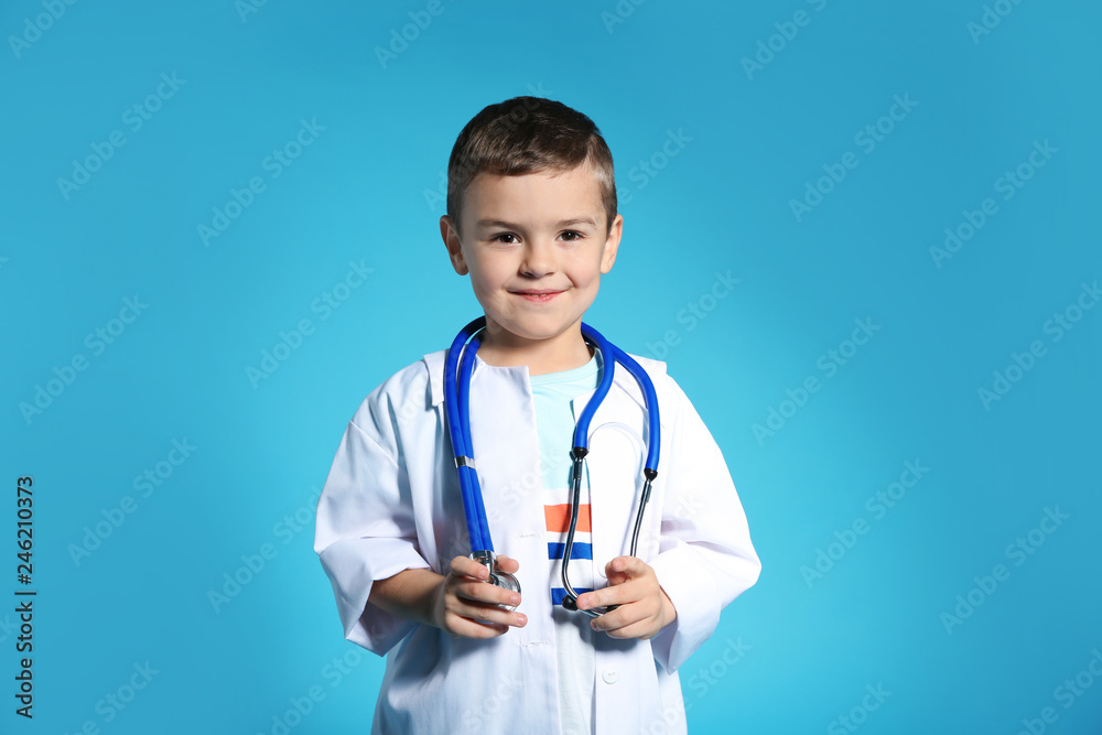 Cute child in doctor coat with stethoscope on color background Cute child in doctor coat with stethoscope on color background