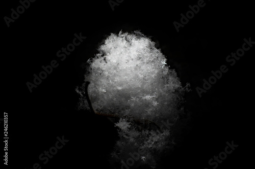 White snow ball made of fluffy snowflakes on a black background