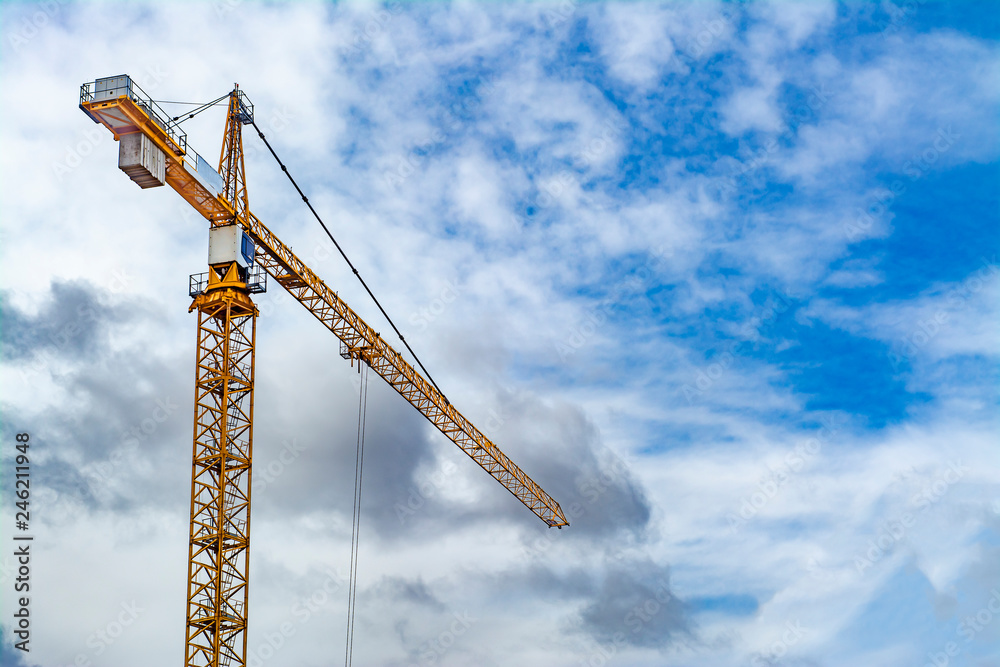 Construction crane against a blue sky and clouds