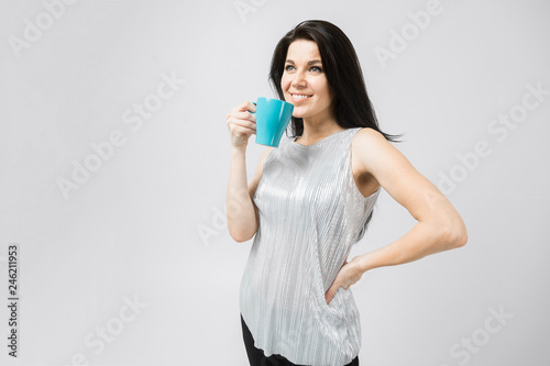 young girl with a turquoise mug stands isolated on a light background
