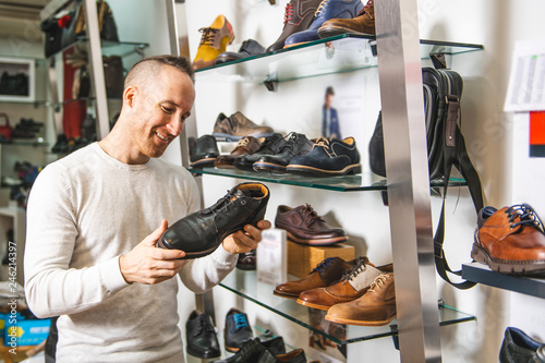 Billede på lærred A man are looking for a new shoes in the shoe shop