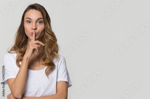 Foto Young woman holding finger on lips mouth to keep it quiet hush standing isolated