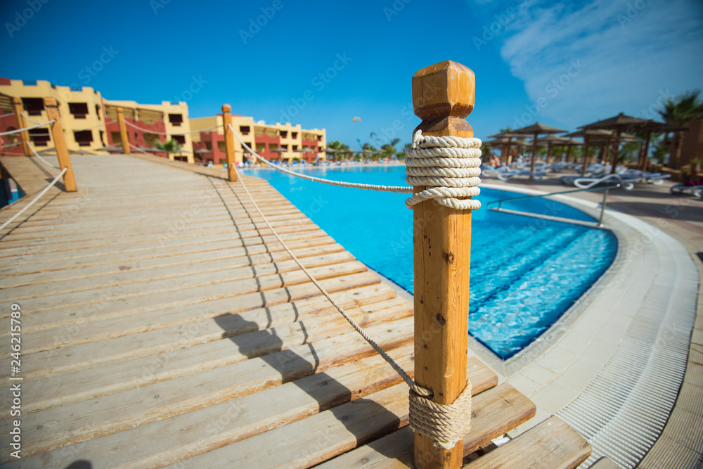Fototapeta premium Bridge over swimming pool at tropical hotel resort