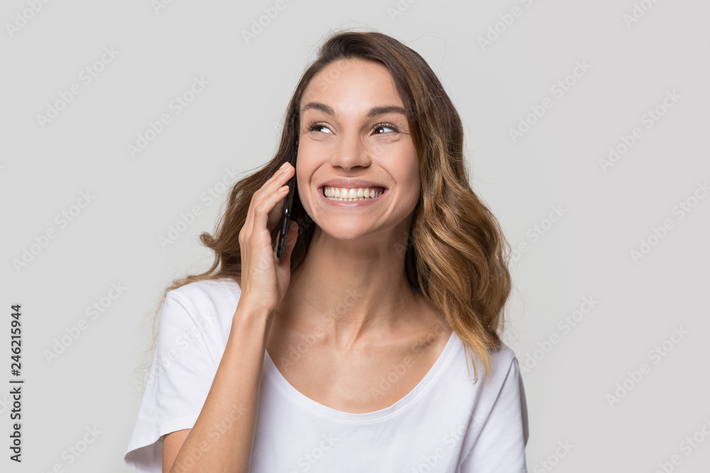 Happy teen girl holding cellphone talking on phone enjoy fun mobile conversation, smiling cheerful young woman caller making call laughing speaking by telephone isolated on blank studio background Happy teen girl holding cellphone talking on phone enjoy fun mobile conversation, smiling cheerful young woman caller making call laughing speaking by telephone isolated on blank studio background