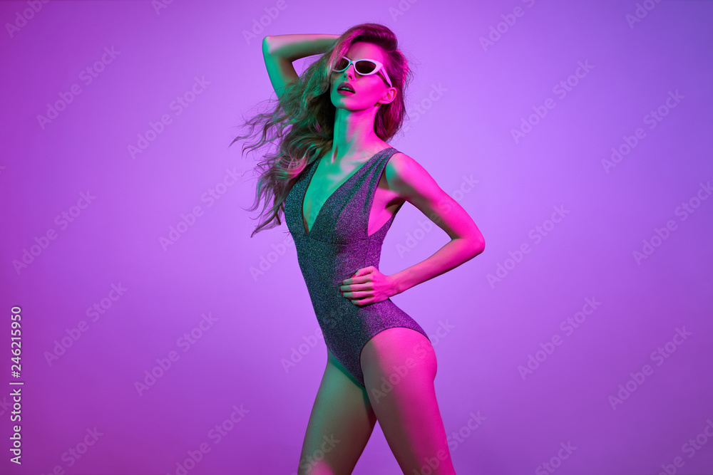 Sexy fashionable model girl dance. Party Disco neon vibes. Young woman with  Trendy wavy hairstyle, Stylish sunglasses. Bright Pink Purple light. Art  fashion neon color Stock Photo | Adobe Stock