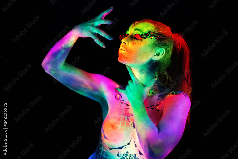Female dancer in bright neon colours under ultraviolet light on background. Female dancer in bright neon colours under ultraviolet light on background.
