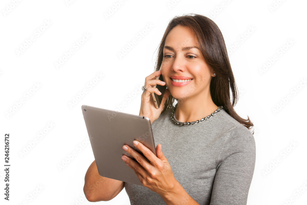 Young professional woman using a tablet and talking on her cellphone isolated on white background Young professional woman using a tablet and talking on her cellphone isolated on white background