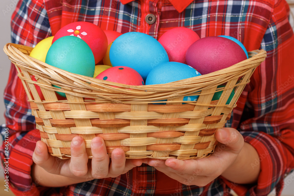 Little kid girl holding a basket of Easter eggs. Close-up Little kid girl holding a basket of Easter eggs. Close-up