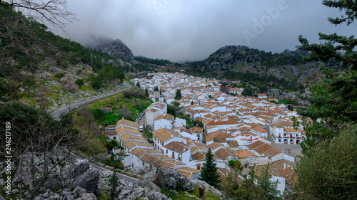 Flowering hawthorn and the mountain town of Grazalema on the path to Ermita del Calvario, Andalucia, Spain photo